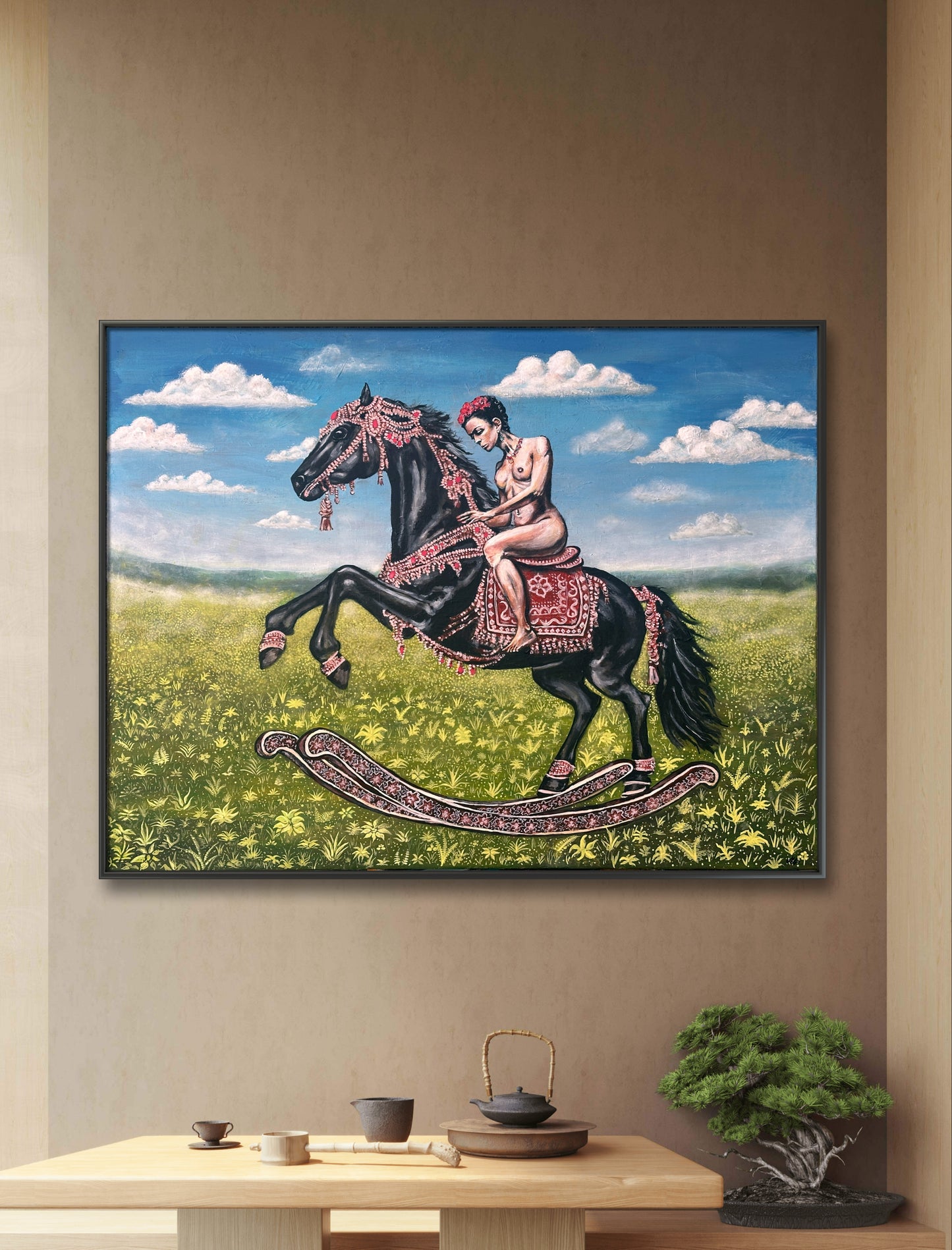 Framed artwork of a woman on a rocking horse in a field with a blue sky.