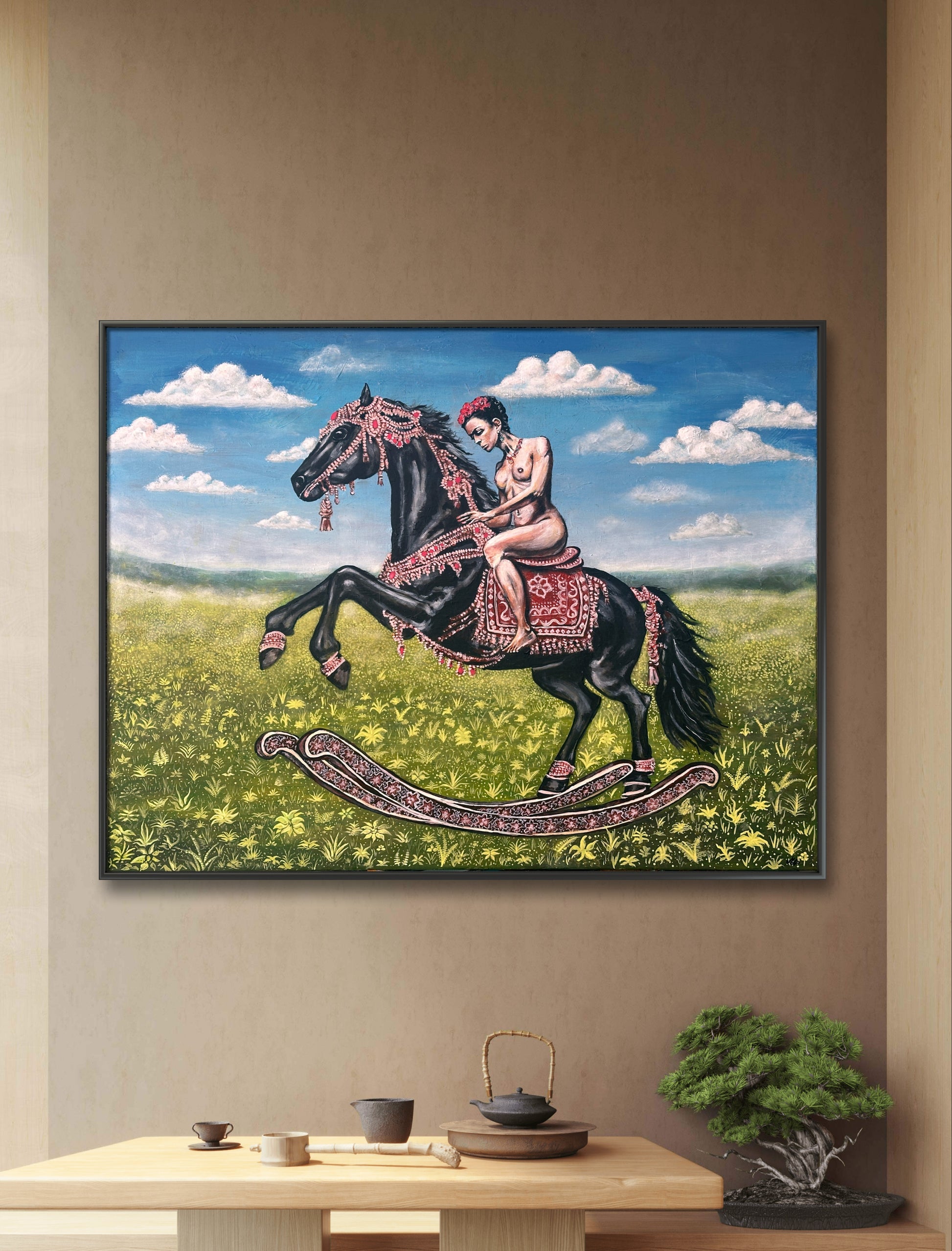 Framed artwork of a woman on a rocking horse in a field with a blue sky.