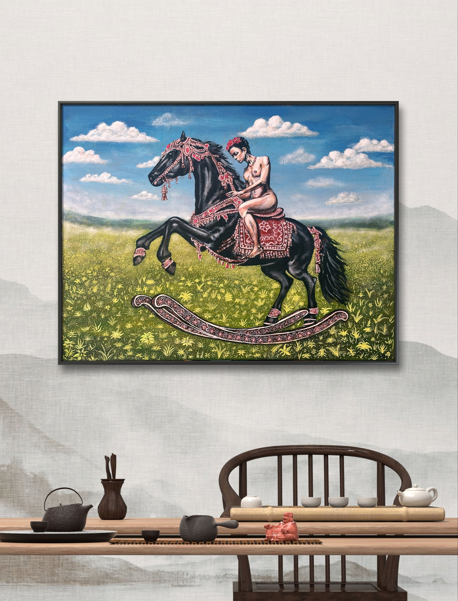 Framed artwork of a woman on a horse in a field with a tea set on a table below.