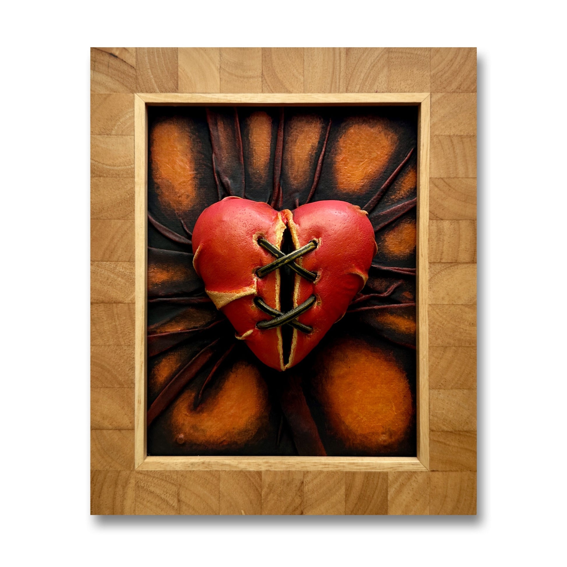 The Broken Lovers Heart leather sculpture in orange, bronze, and crimson hues.