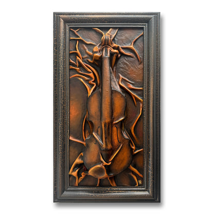 Decorative wall art with a violin design in a bronze frame on a white background