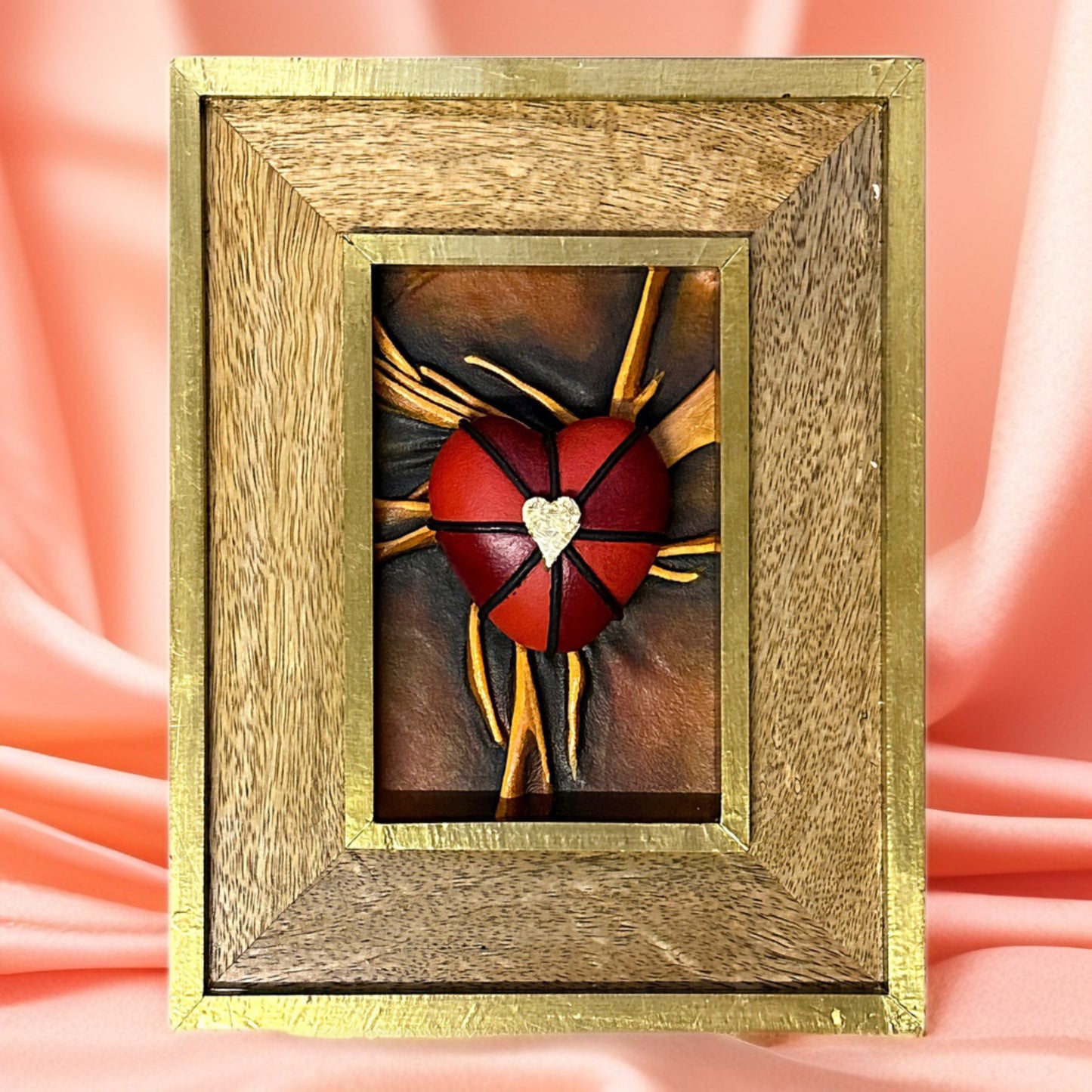 Genuine leather heart sculpture adorned with vibrant black, red, and gold details, in a sophisticated wooden frame.