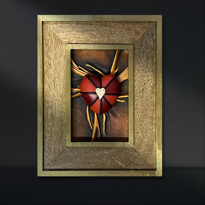 Exquisite leather heart artwork, meticulously painted with black, red, and gold, housed in an elegant wooden frame.