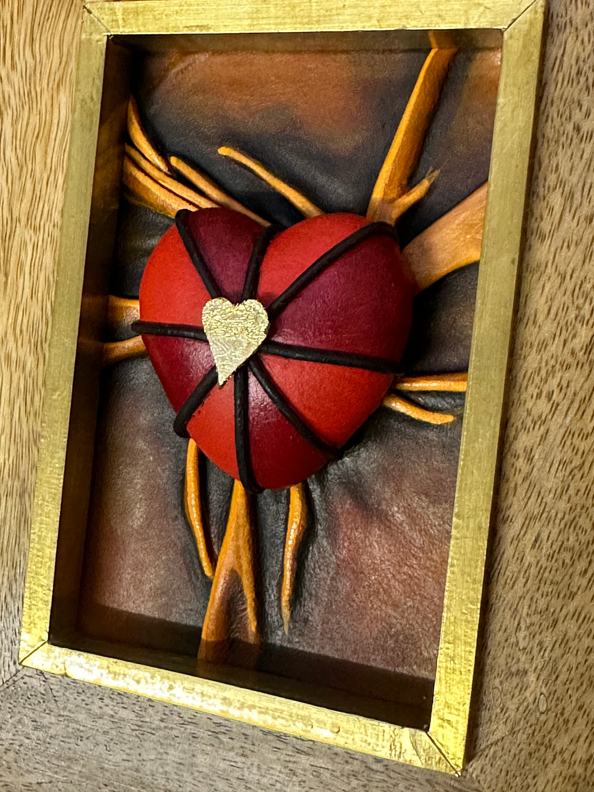 'Lovers Heart - Love Repaid' leather sculpture, featuring intricate black, red, and gold acrylic painting, framed elegantly.